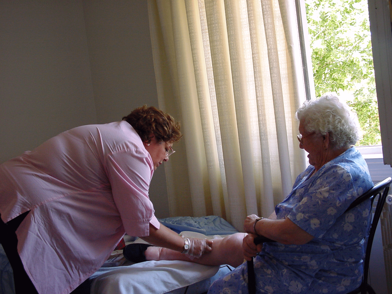 Enfermera atendiendo a una anciana