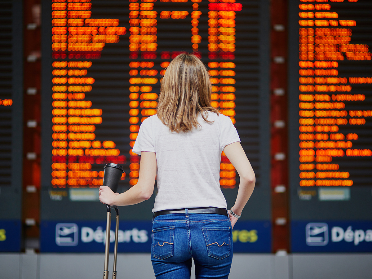 Mujer observa las pantallas de un aeropuerto