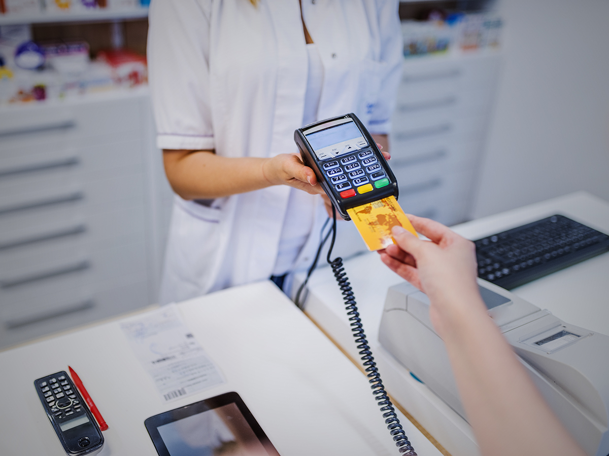 Mujer realiza el pago con tarjeta de crédito en una farmacia