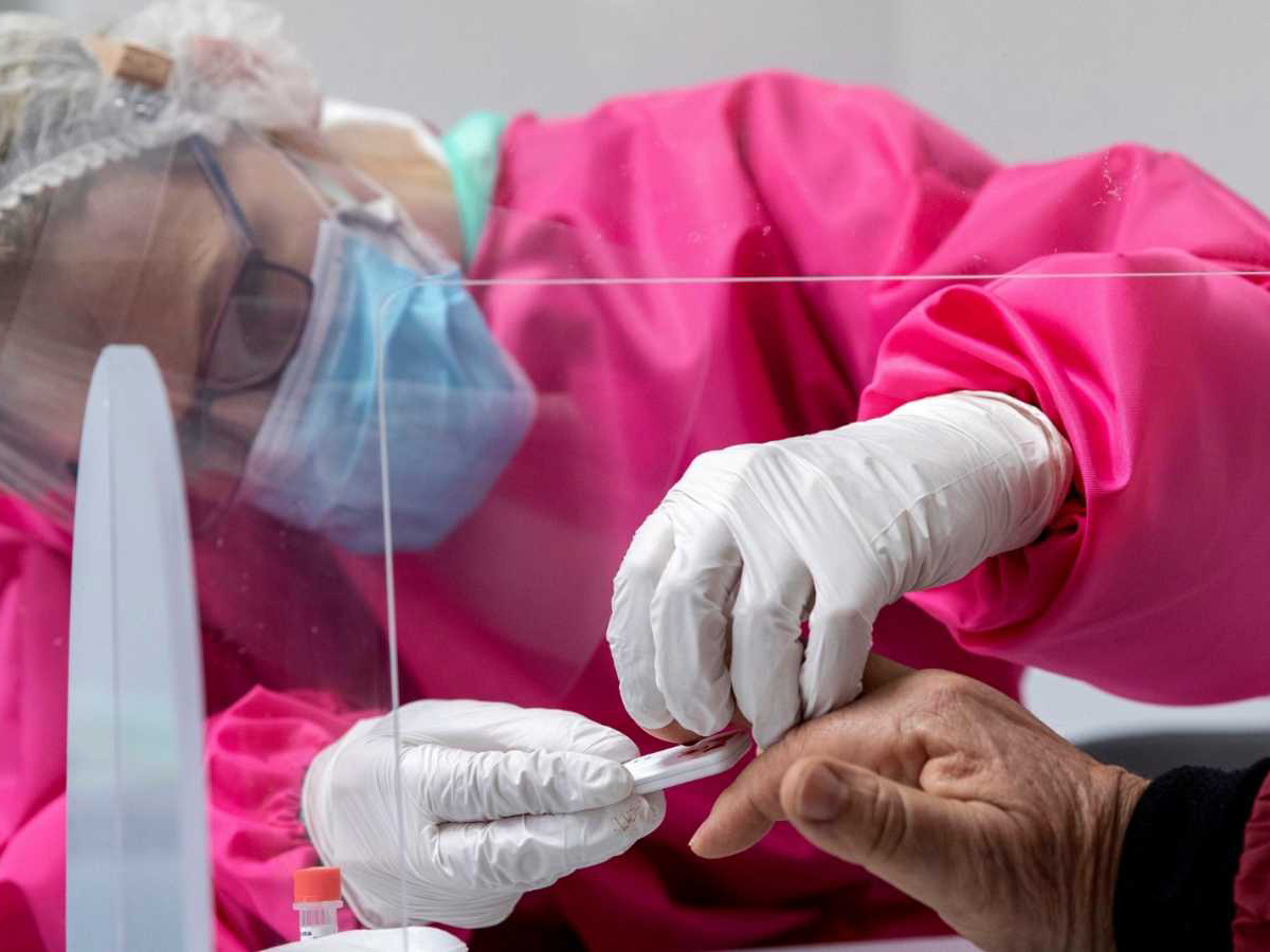 Una enfermera de Atención Primaria toma una muestra de sangre de una persona mayor en plena crisis del COVID 19