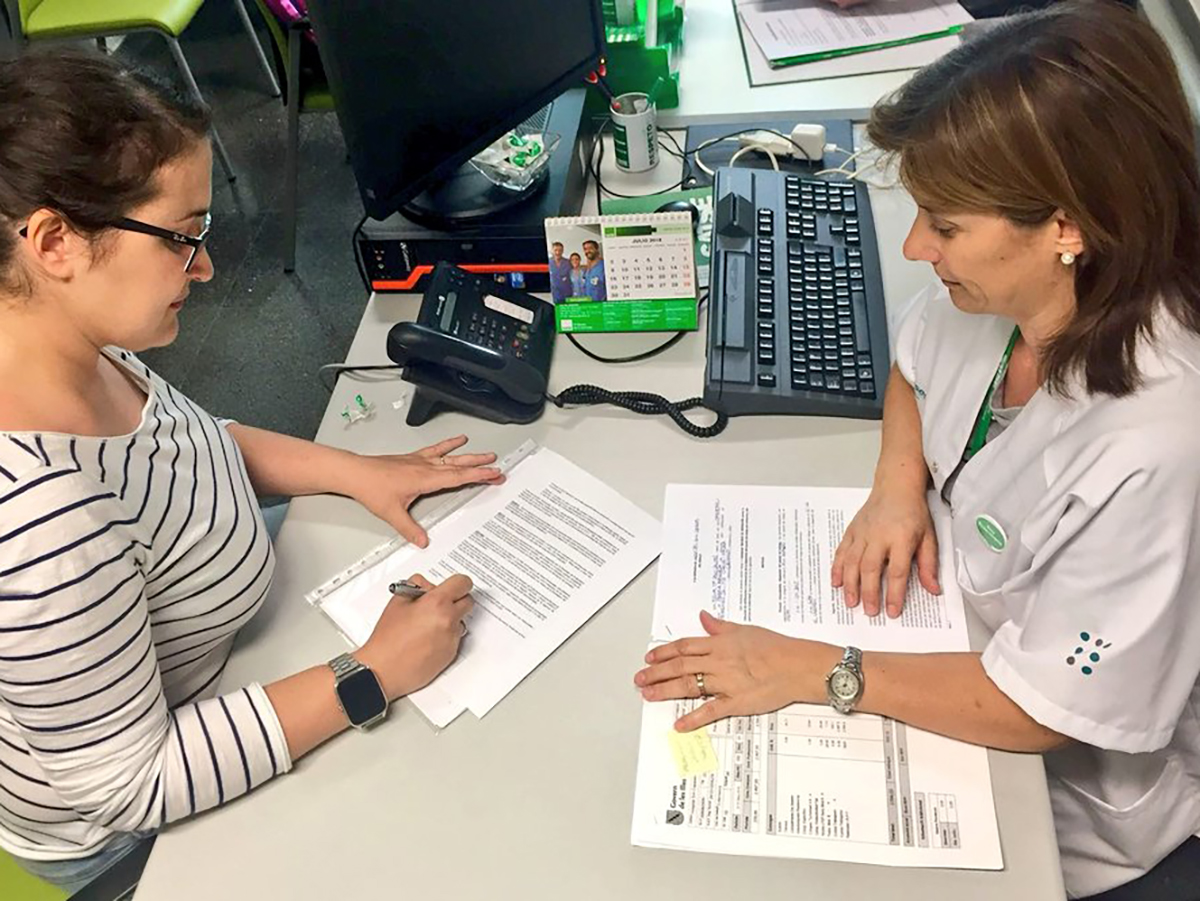 Enfermera lee un documento proporcionado por una compañera y delegada de SATSE